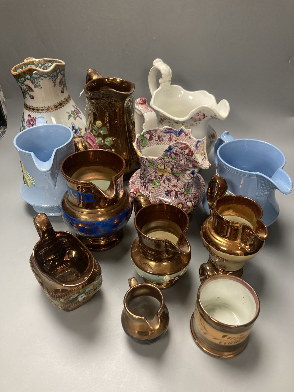 A collection of eleven lustre jugs and a mug, tallest 21cm